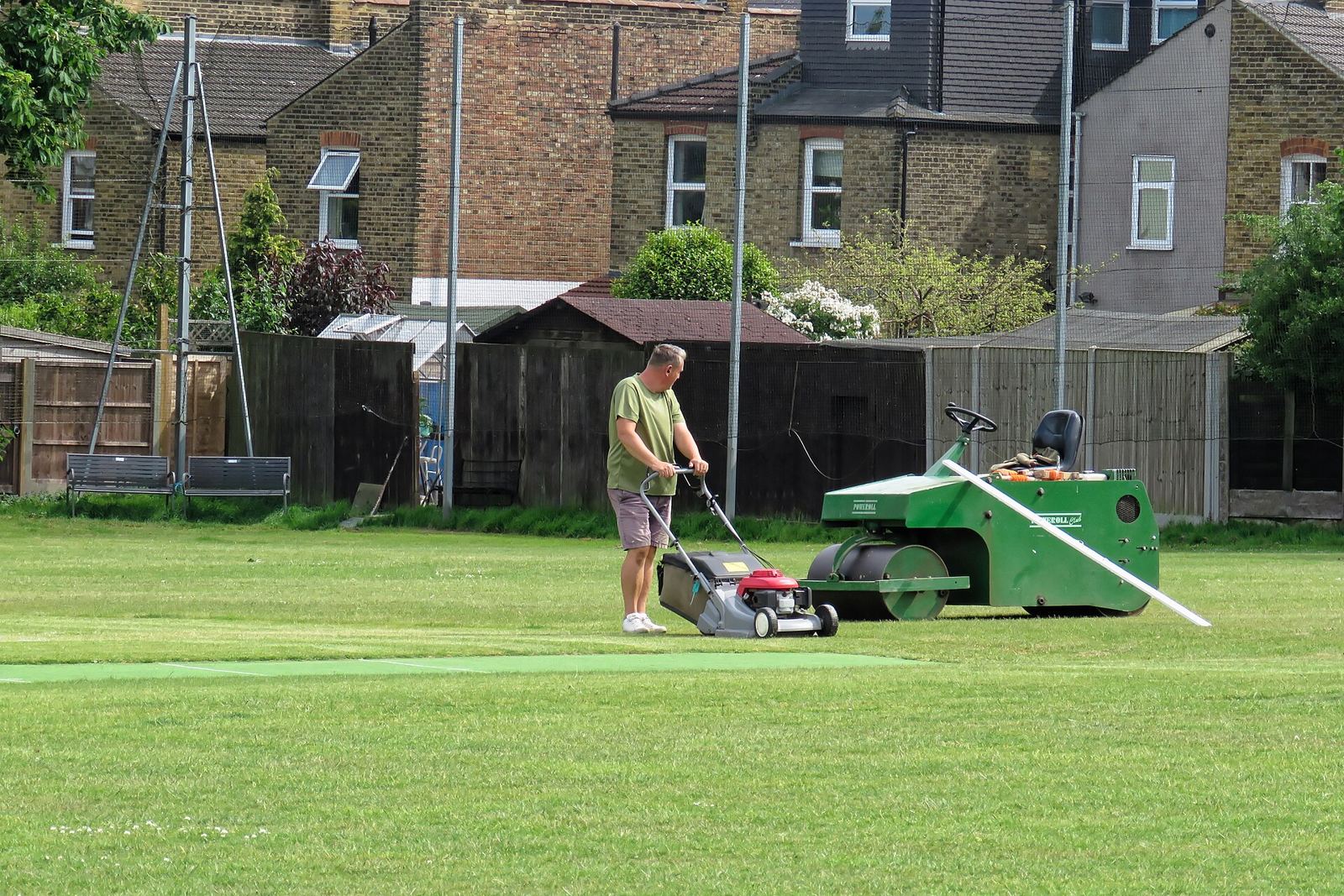 Groundsman mowing a cricket square
